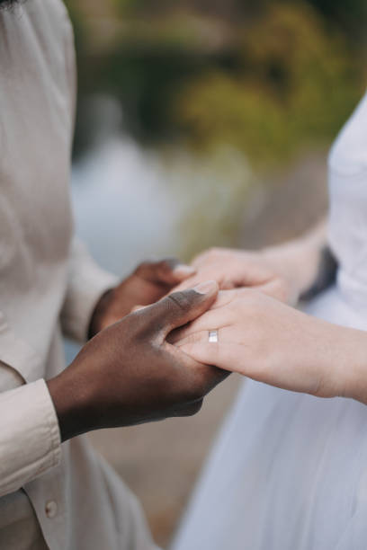 istock Interracial couple newlyweds holds each other hands. 1489475767