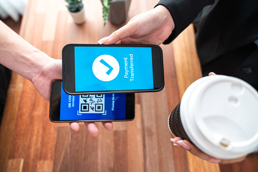 Seamless cashless payments with barcode scanning on smartphone application. Utilizing QR code technology, secure and fast transactions for modern shopping lifestyle with mobile banking app. Jubilant