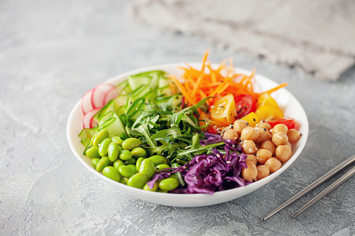 Buddha Bowl. Cucumber, carrot, arugula, red cabbage, edamame beans and sesame seeds. The concept of delicious balanced and healthy food.