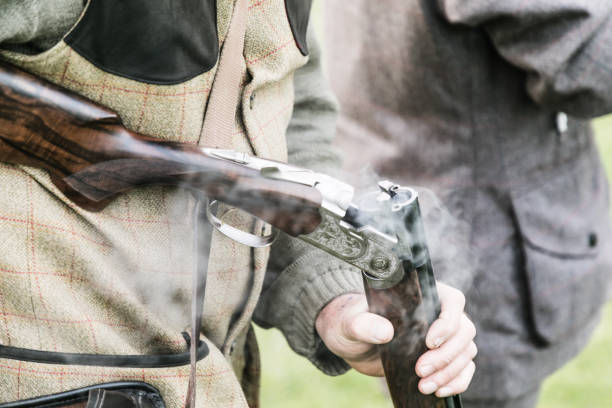 A gun 'loader' ejecting cartridges from a shotgun on a pheasant shoot on the estate at Woodstock, Oxfordshire.