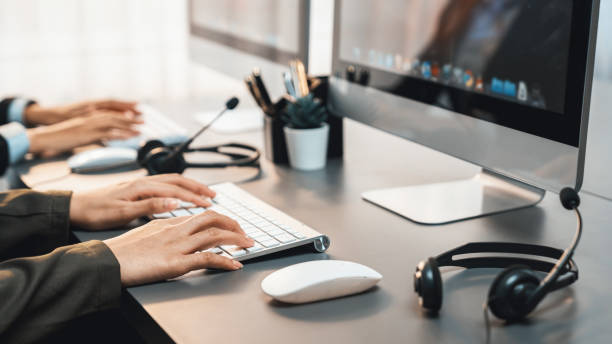 istock Panorama focus headset on call center workspace desk with blur operator. Prodigy 1489480234