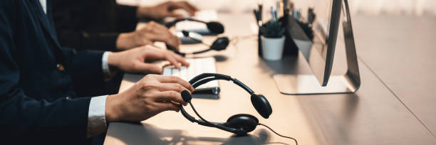 istock Panorama focus headset on call center workspace desk with blur operator. Prodigy 1489480374