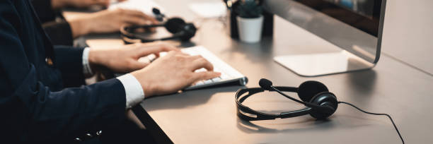 istock Panorama focus headset on call center workspace desk with blur operator. Prodigy 1489481165