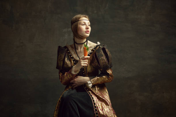 ritratto di giovane ragazza, principessa, persona reale in abito vintage in posa con carota su sfondo verde scuro. - princess diet foto e immagini stock