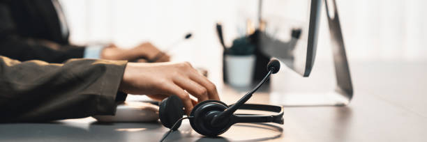 istock Panorama focus headset on call center workspace desk with blur operator. Prodigy 1489481631