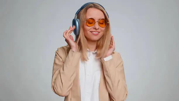 Photo of Happy business woman in headphones listening music dancing disco having fun relaxing on party