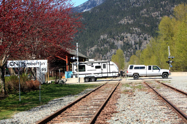 Pemberton CN Rail Track With Truck And Trailer At Crossing, Pemberton, British Columbia, Canada- April 27,2023: Railway crossing in Pemberton BC. Truck and Trailer traveling across. pemberton town stock pictures, royalty-free photos & images