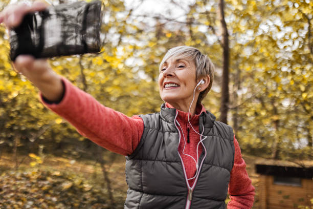 istock Mature woman posing at smartphone camera making selfie 1489494559