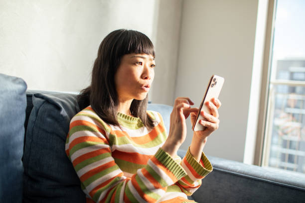 istock Young Japanese Woman using a smart phone at home 1489496250