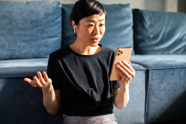 istock Young Japanese woman using a smart phone after exercising at home 1489496667