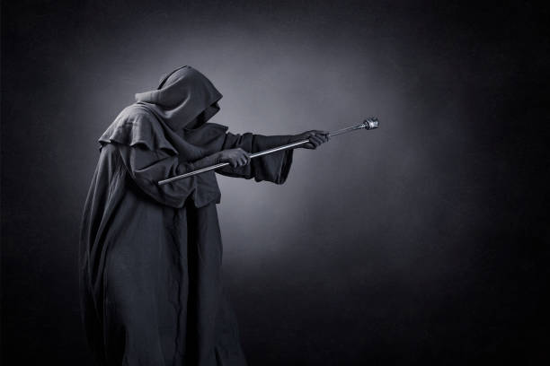 istock Wizard with hooded cape and magic staff over dark misty background 1489498080