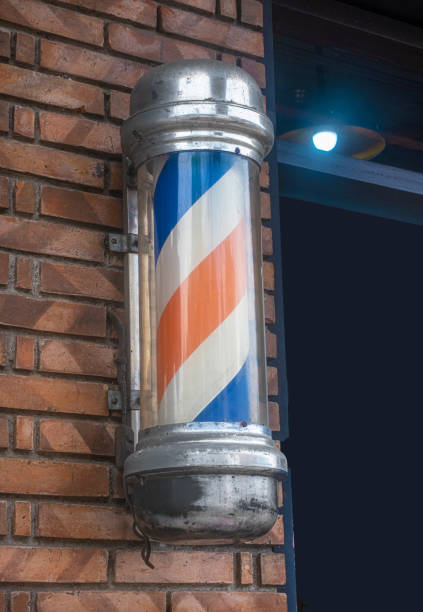 istock Barber's pole on brick wall with glowing lamp 1489501785