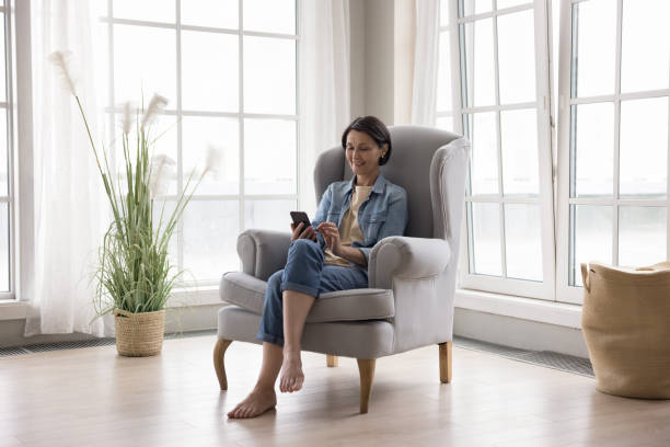istock Positive relaxed mature lady using online application on mobile phone 1489504313