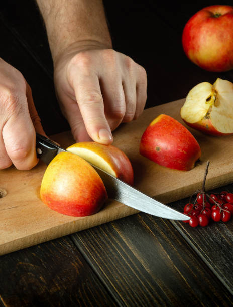 istock The chef cuts apples on a cutting board to make compote or fruit juice. Apple diet for a set of vitamins. Work environment on the kitchen table 1489506392