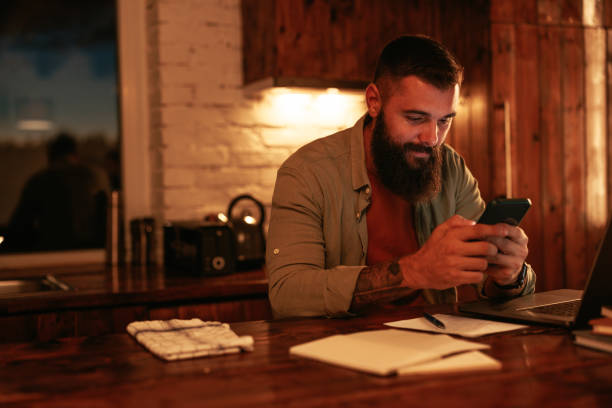 istock Young man using cellphone late in evening at home. 1489507214