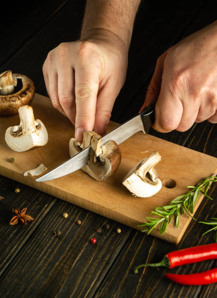istock The chef hands cut mushrooms with a knife on a kitchen cutting board before preparing a vegetarian dinner with herbs and spices. Copy space. 1489507883