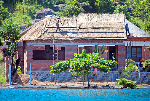 New thatched roof building, Masaka Fishing Village, Lake Malawi, Malawi, Africa. Malawi, the landlocked country in southeastern Africa, is a country of highlands split by the Great Rift Valley and the huge Lake Malawi, whose southern end is within Lake Malawi National Park and several other parks are now habitat for diverse wildlife from colorful fish to the Big Five. Cape Maclear is known for its beach resorts, whilst several islands offer rest and recreation.