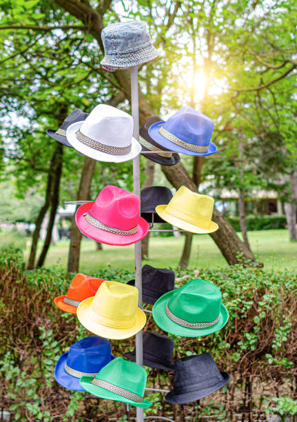 Hanger with hats on the street. Tourist hats of different colors are sold on the street.