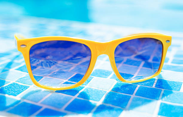 istock Yellow sunglasses on a background of a pool. 1489509197