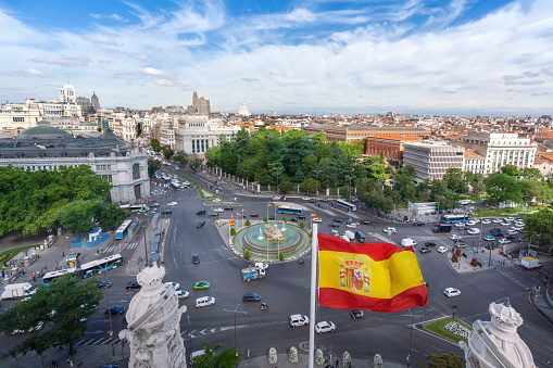 Aerial view of Calle de Alcala Street and Plaza de Cibeles with the Spanish Flag - Madrid, Spain
