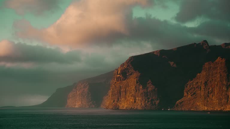 Ocean rocky shore with rough sea and volcanic cliffs on the rugged Atlantic coast in Tenerife.