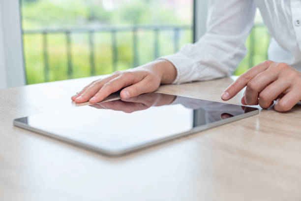 istock Tablet with a blank screen in the hands on wooden table 1489514415