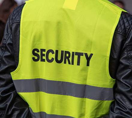 Security. Close-up of a yellow guard's vest.
