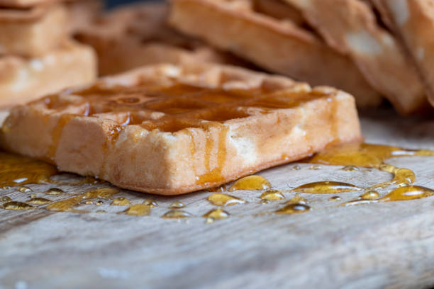 Soft fresh waffles with bee honey close-up, delicious and fresh dessert of soft waffles