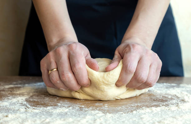 istock Making dough, close-up of female hands kneading dough for baking bread, 1489519339