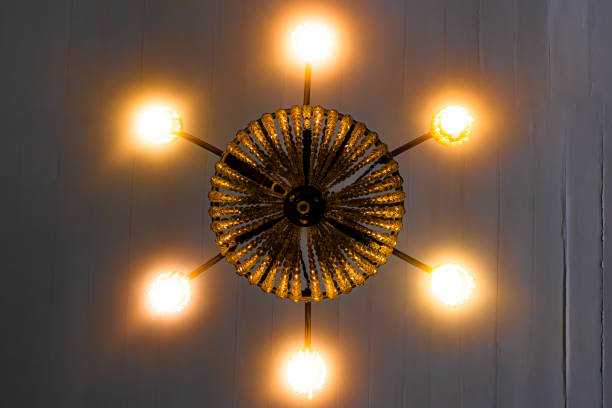 istock Ceiling chandelier in Convento da Penha with yellow lights and white background. 1489522899