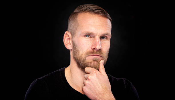 istock Young man with a beard on a black background. 1489522990