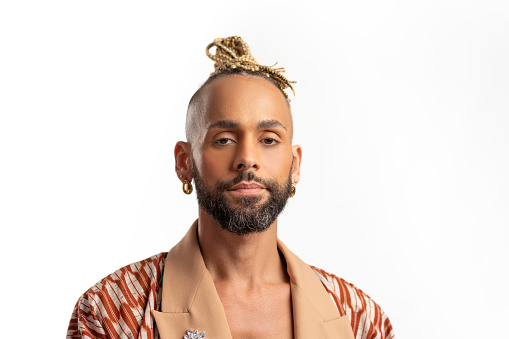 Confident black gay man standing isolated on white background, dressed in a bold, colorful jacket. Exudes sense of pride and individuality. Diversity power of personal style
