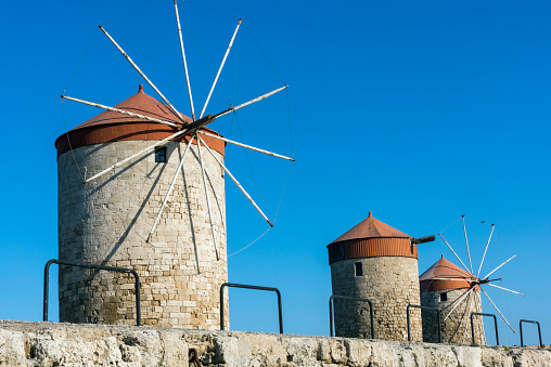 Windmills at the seafront in the city of Rhodes in Rhodes island in Greece