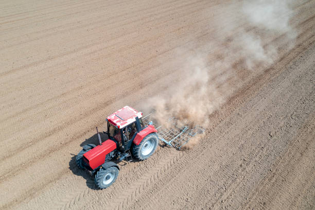 istock Tractor plows a field, aerial view 1489536827