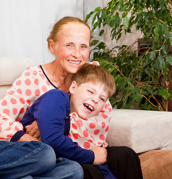 Laughing grandson hugs with grandmother stock photo