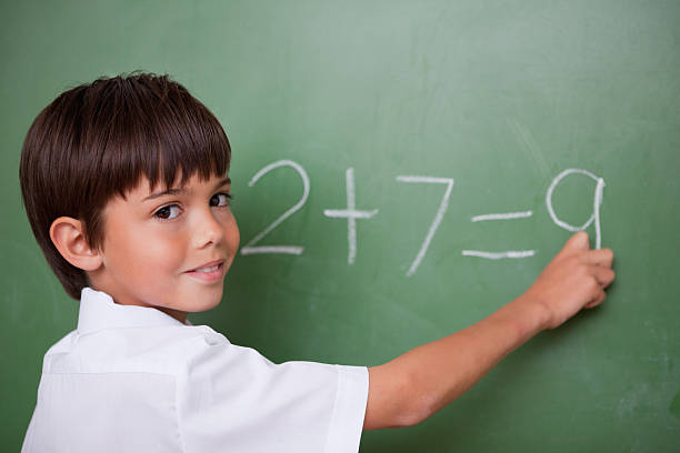istock Happy schoolboy writing an addition 148955090