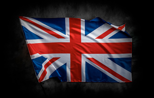 UK flag on a dark background. Great Britain flag on the background of a dark canvas for a patriotic concept and national celebrations.