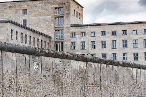 segment of the Berlin Wall, covered in graffiti with part of it having only the steel reinforcing rods still standing.  Viewed from East Berlin into West Berlin.