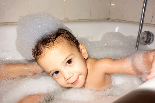 Cute boy taking a bath in the tub