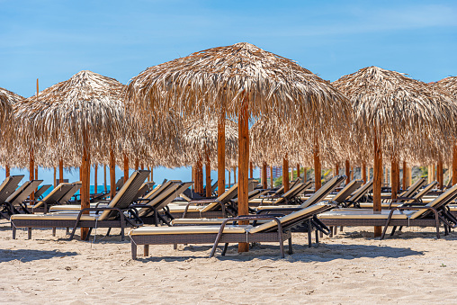 Straw beach umbrellas and sun loungers for relaxing by the sea.