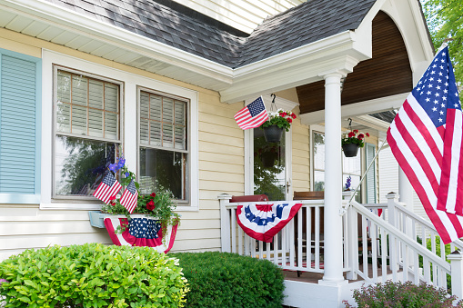 Charming traditional home with front porch decorated for the 4th of July