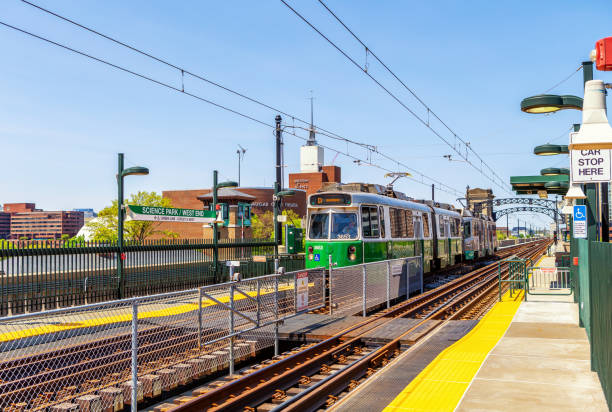 Boston, Massachusetts, USA - May 10, 2023: Train entering MBTA's Green Line Science Park/West End subway station. Boston's Museum of Science in the background.