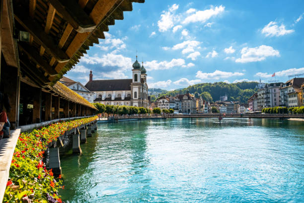 Switzerland travel - A view of the Jesuitenkirche and Rathaussteg pedestrian bridge on the river Reuss from the Chapel bridge A view of the Jesuitenkirche and Rathaussteg pedestrian bridge on the Reuss River seen from the Chapel bridge in Lucerne, Switzerland. lucerne switzerland stock pictures, royalty-free photos & images
