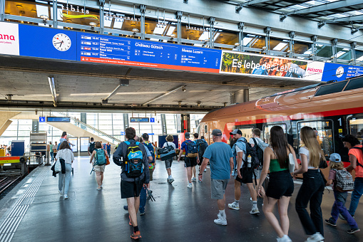 Lucerne, Switzerland - July 10, 2022: travelers moving through the Lucerne central railroad terminal from train platform to terminal.