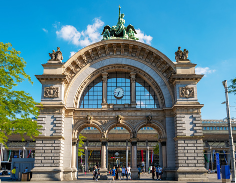 Lucerne, Switzerland - July 10, 2022: The original archway to the entrance of the Lucerne railway station. The old building had been destroyed in a major fire in 1971. The main entrance to the old station survived the fire and now stands as an imposing gateway in the middle of the station forecourt.