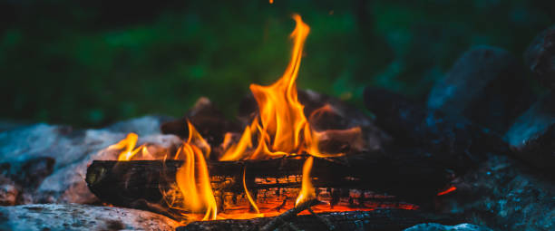 istock Vivid smoldered firewoods burned in fire close-up. Atmospheric warm background with orange flame of campfire. Unimaginable full frame image of bonfire. Burning logs in beautiful fire. Wonderful flame. 1489567175