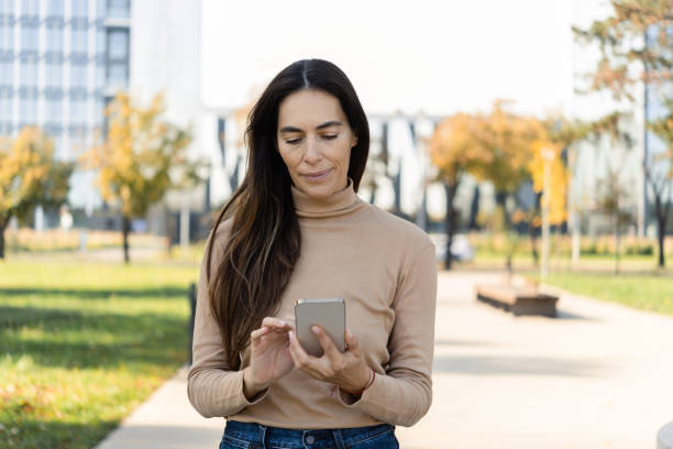 istock Woman using smartphone on the street 1489567206