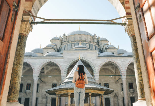 A young female traveler with a backpack on her back walks towards the Fatih Mosque in Istanbul A young female traveler with a backpack on her back walks towards the Fatih Mosque in Istanbul. anhui province stock pictures, royalty-free photos & images