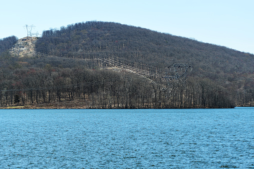 The Monksville Dam and reservoir cuts through a naked bare mountainous region and wilderness on an early spring day in a Ringwood state park.