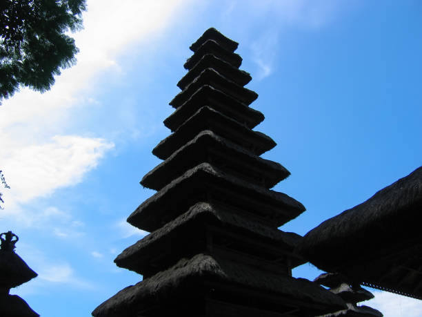 tetto del tempio della pagoda sagomato contro un cielo blu al tempio di goa lawah o al tempio della grotta dei pipistrelli nella parte orientale di bali, in indonesia. localmente conosciuto come pura goa lawah. - pura goa lawah foto e immagini stock